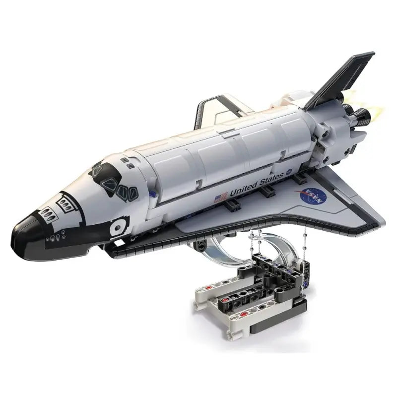 White plastic toy model of a space shuttle on a clear and gray stand with detailed engines and small american flag