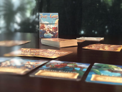 Take the Gold card game box, showing anthropomorphic pirate art, with scattered cards on a dark table.