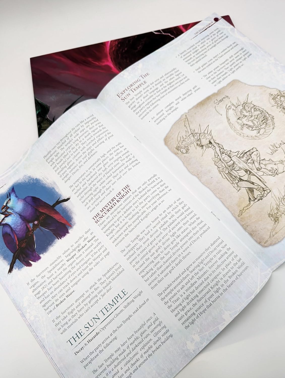 Open tabletop RPG book with text, featuring a blue bird-like creature and skeletal monster concept art