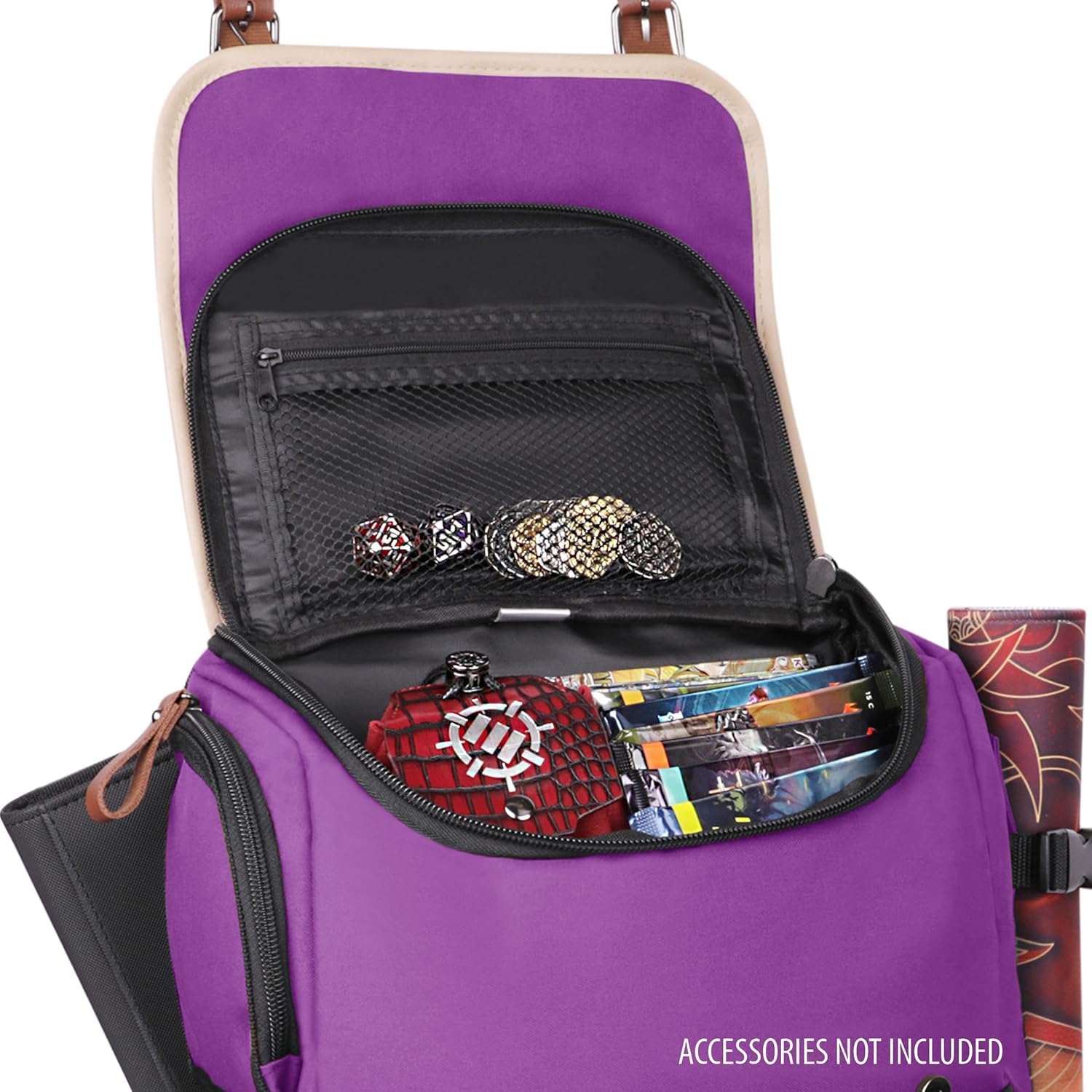 Open purple bag filled with gaming dice, coins, card packs, and a red case. Rolled mat attached. Text: Accessories not included.