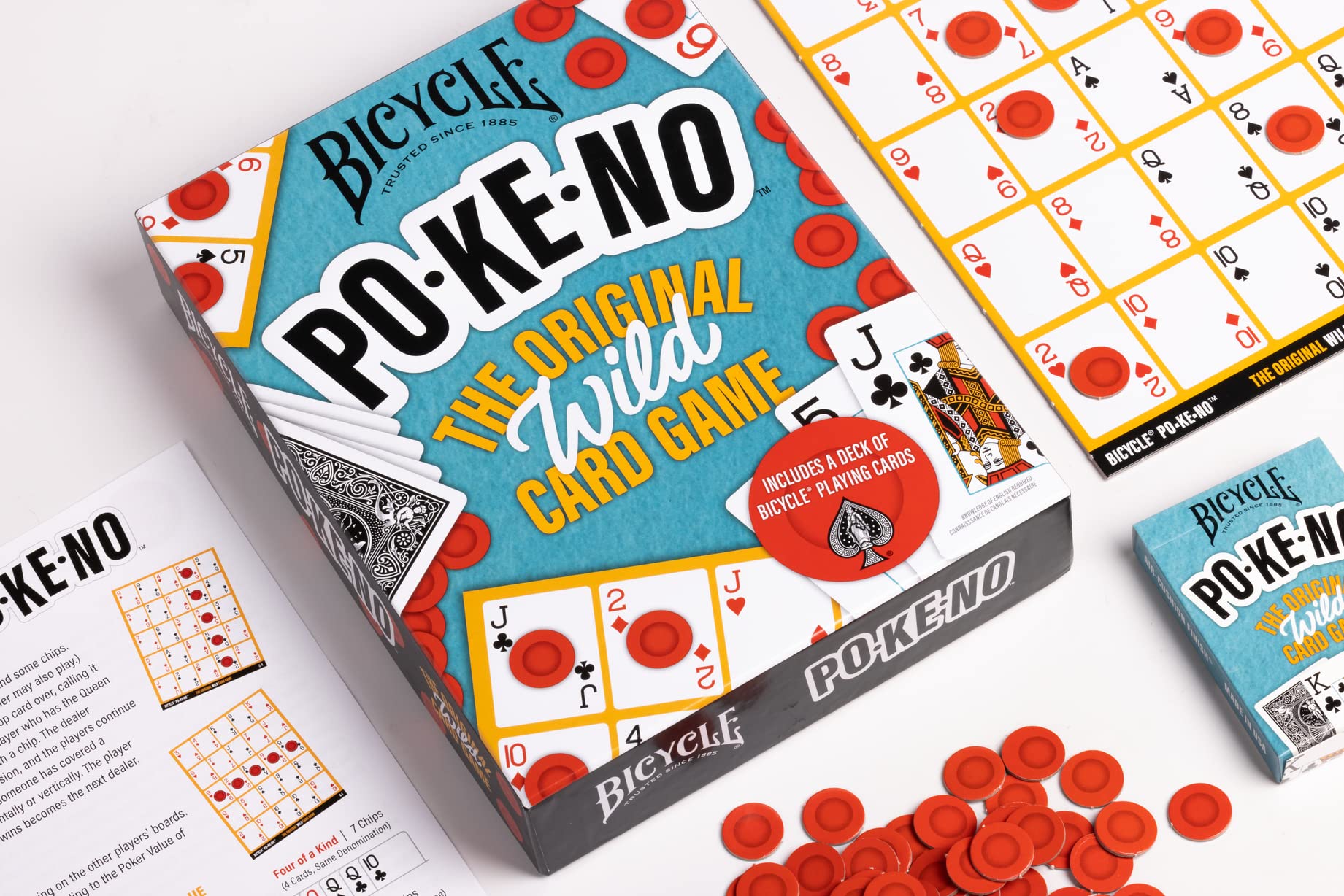 Bicycle PO-KE-NO card game box open, showing playing cards, red chips, and game boards. An unopened game box is nearby