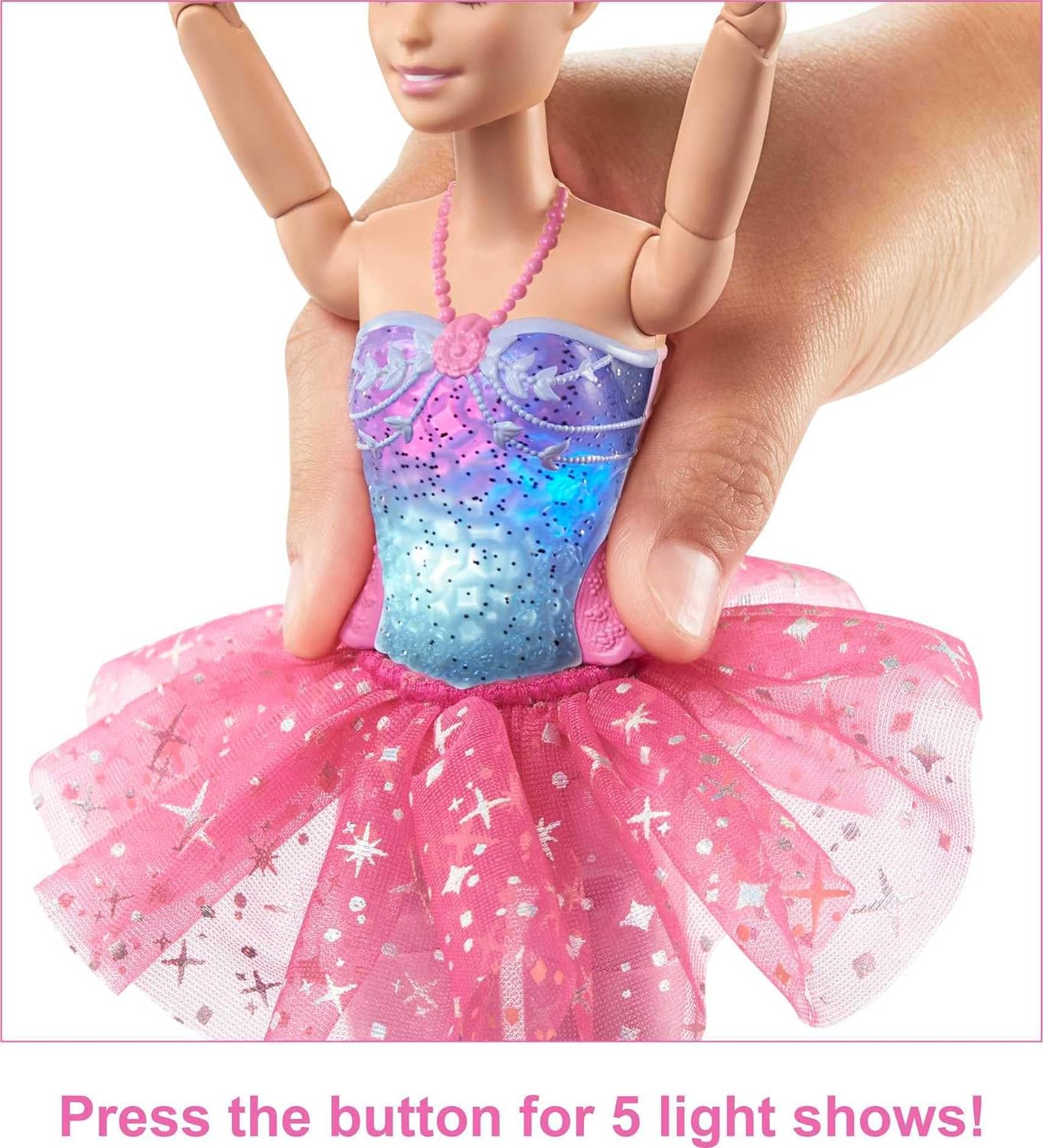 Barbie doll with light-up purple-blue bodice and pink tutu; a hand presses a back button