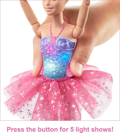 Barbie doll with light-up purple-blue bodice and pink tutu; a hand presses a back button