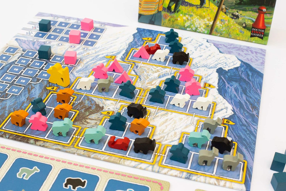 Nanga Parbat board game featuring colourful wooden meeples, animal tokens, and tents on a snowy mountain map, with the game box behind
