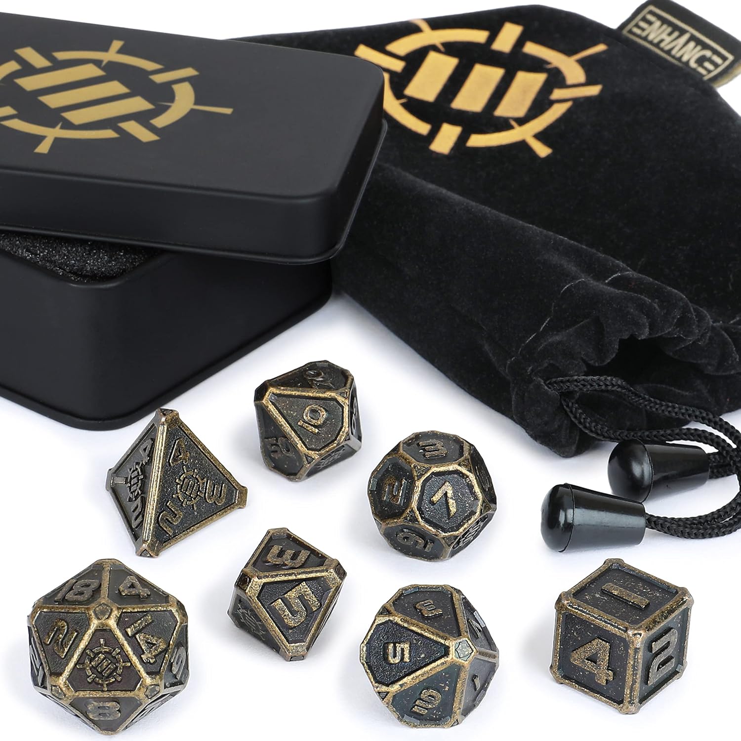 A set of antique bronze metal dice scattered on white, with an open black tin and velvet pouch