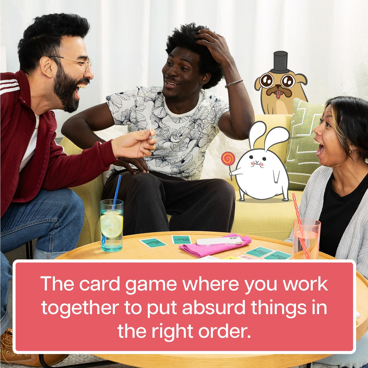 Three friends laugh while playing Grab &amp; Game That Escalated Quickly around a table with cards and two cartoon animal characters