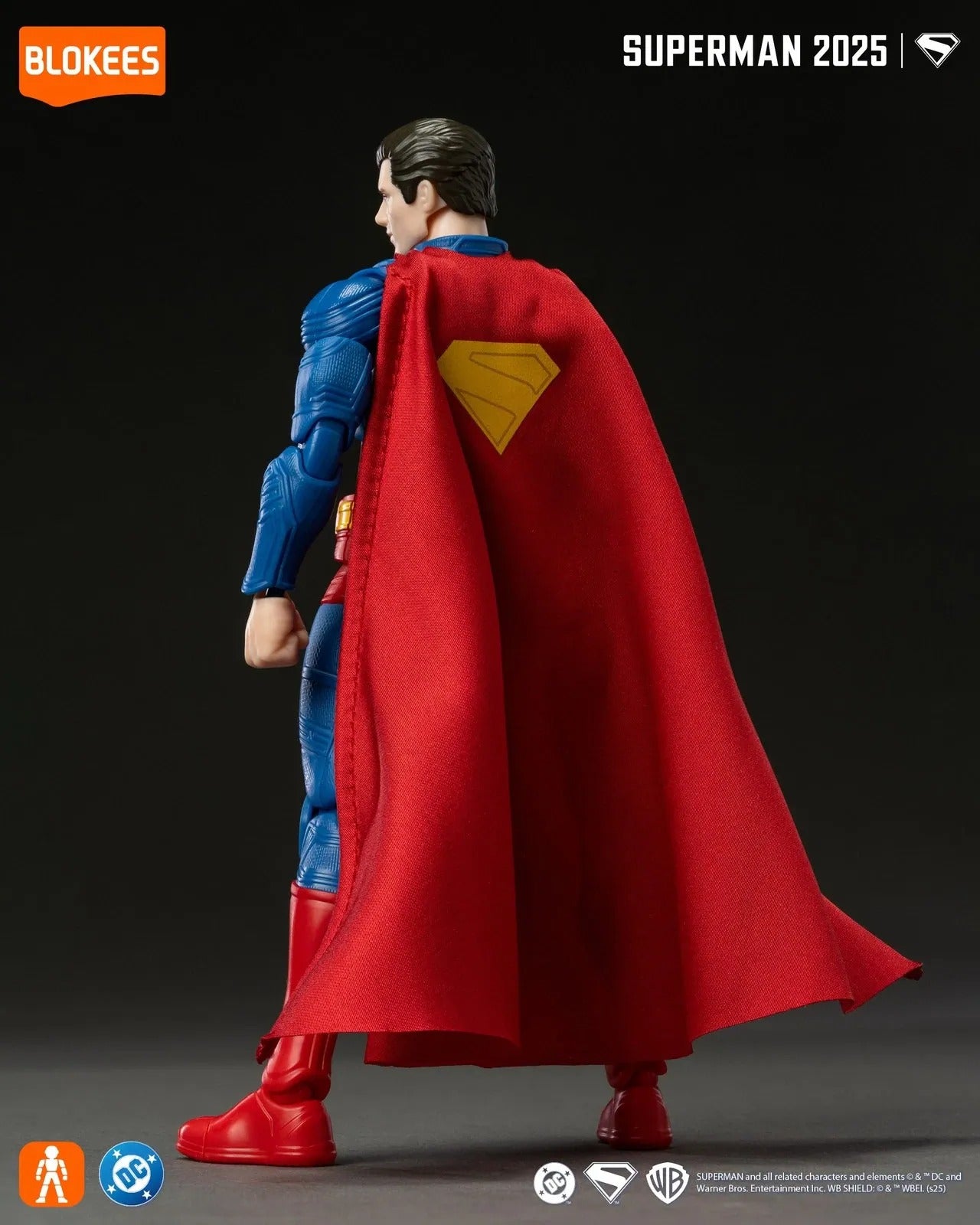 Superman action figure (back view) in blue suit and red cape with yellow S-shield emblem
