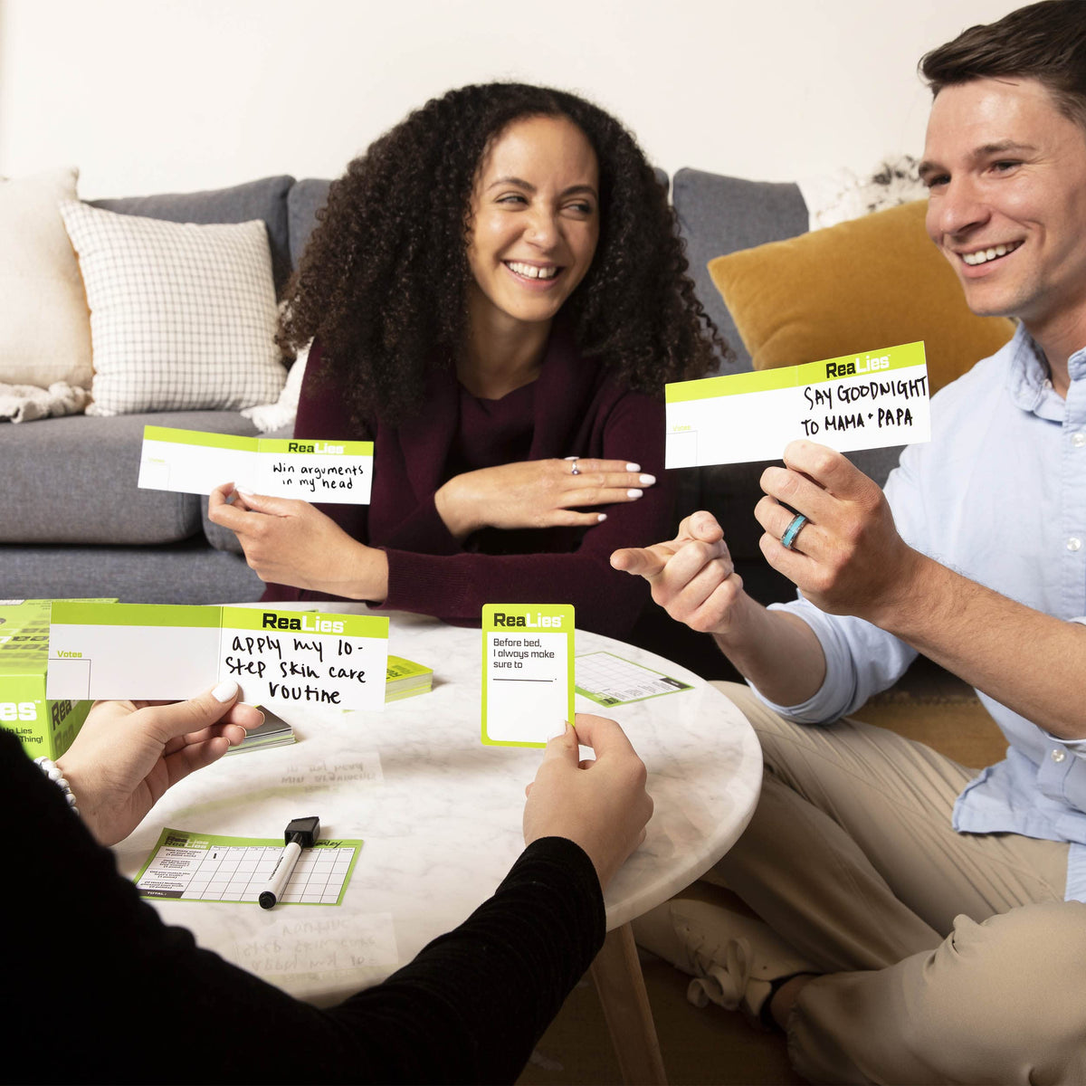 Players holding What Do You Meme: ReaLies cards while playing
