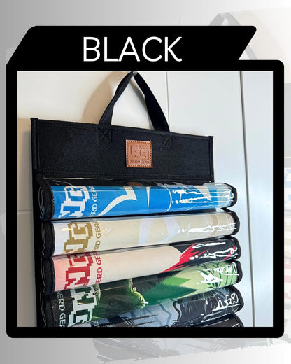 Black felt hanging organizer holding five colorful rolled-up gaming mats in clear pockets