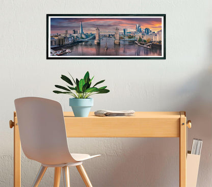 Framed photo of London's Tower Bridge and skyline at sunset displayed above a wooden desk