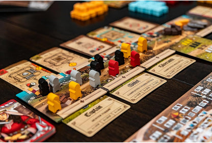 Wooden meeples placed on job cards and territory tiles during a strategy board game session