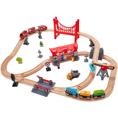 Assembled wooden train set featuring passenger and cargo trains, a large red suspension bridge, and a station