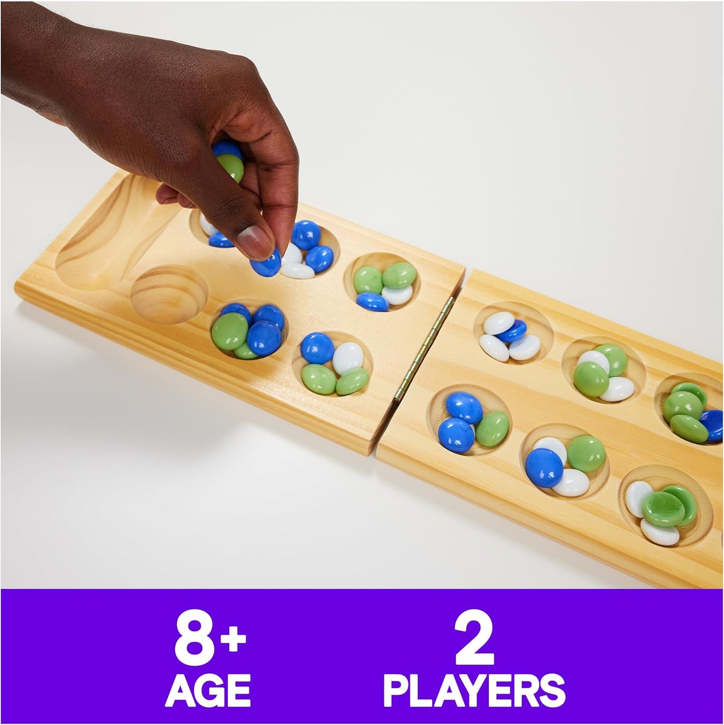 A player moves blue and green glass stones on a wooden Mancala game board