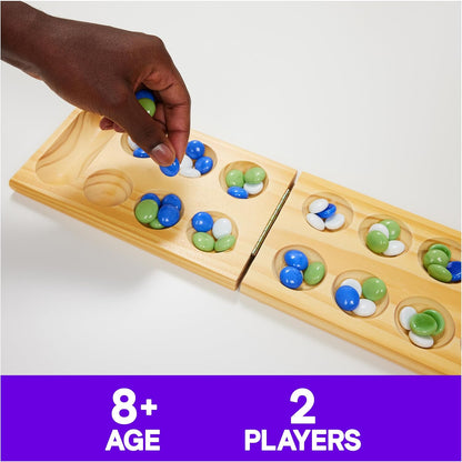 A player moves blue and green glass stones on a wooden Mancala game board