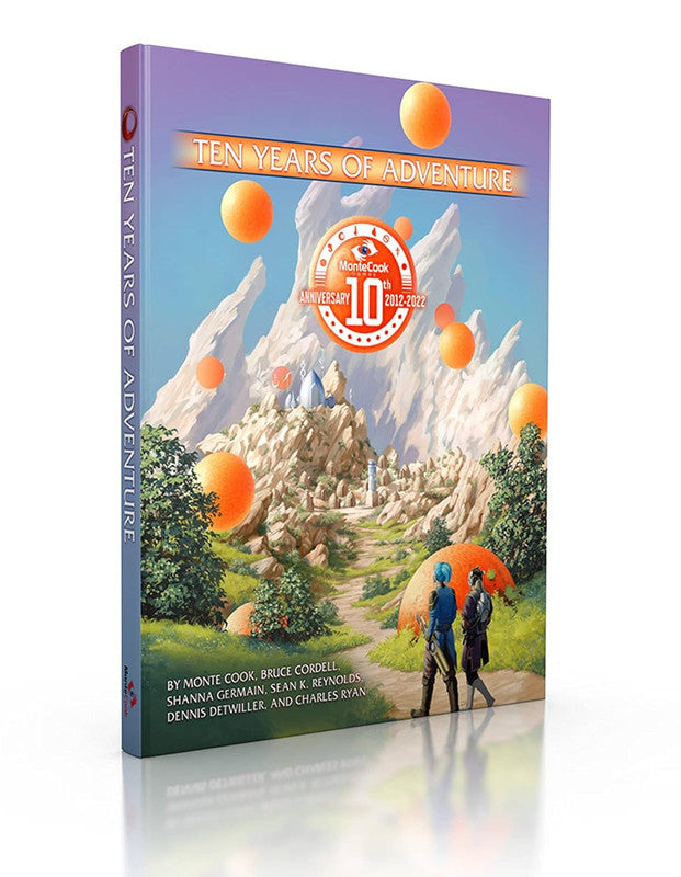 Monte Cook Games Ten Years of Adventure commemorative hardcover book features a vibrant sci-fi landscape with floating orange spheres and two figures walking on a path