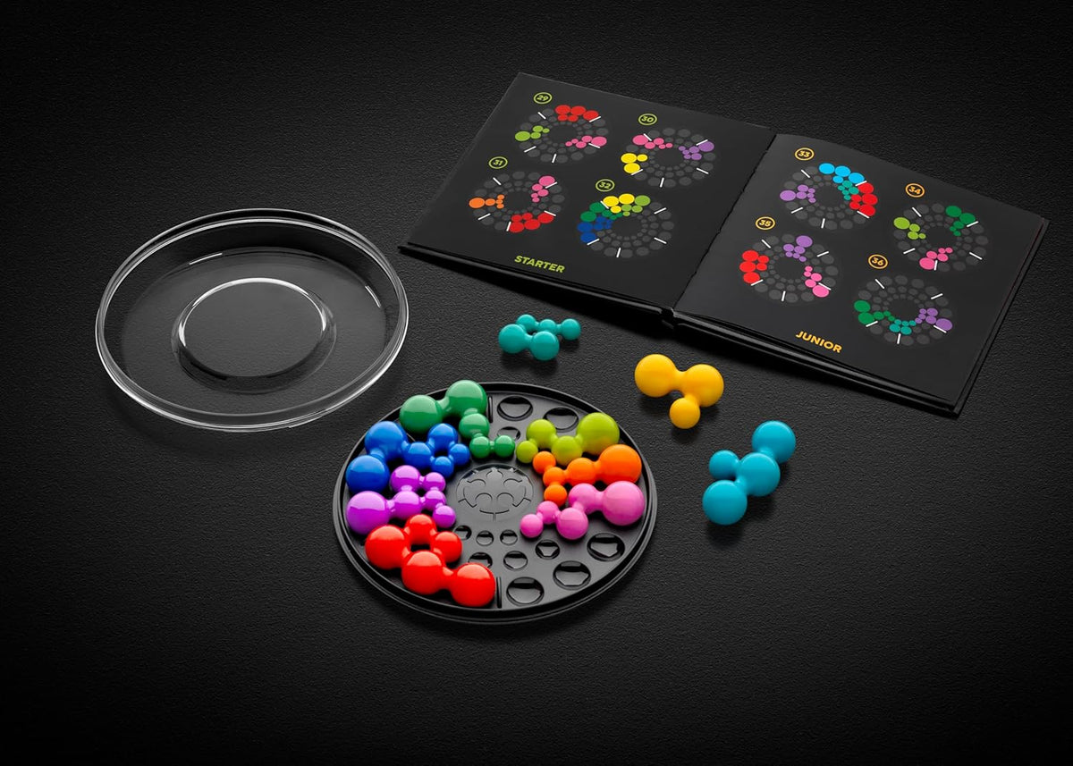 IQ Deluxe Circle logic puzzle game pieces (molecule shapes) on a black circular board, shown next to an instruction book
