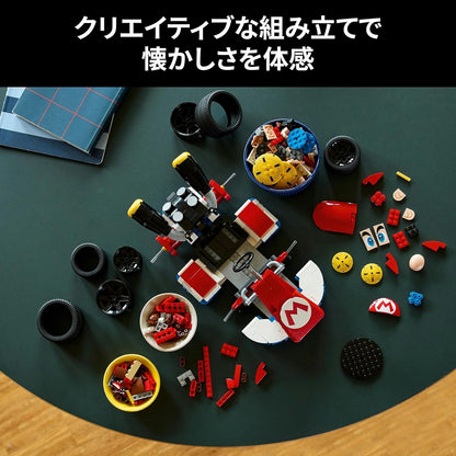 Partially built red Mario Kart made of plastic bricks, surrounded by spare parts, tires, and component bowls