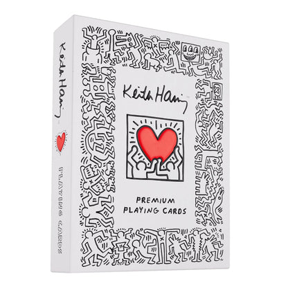Keith Haring playing card box with black line art figures and a central red heart graphic