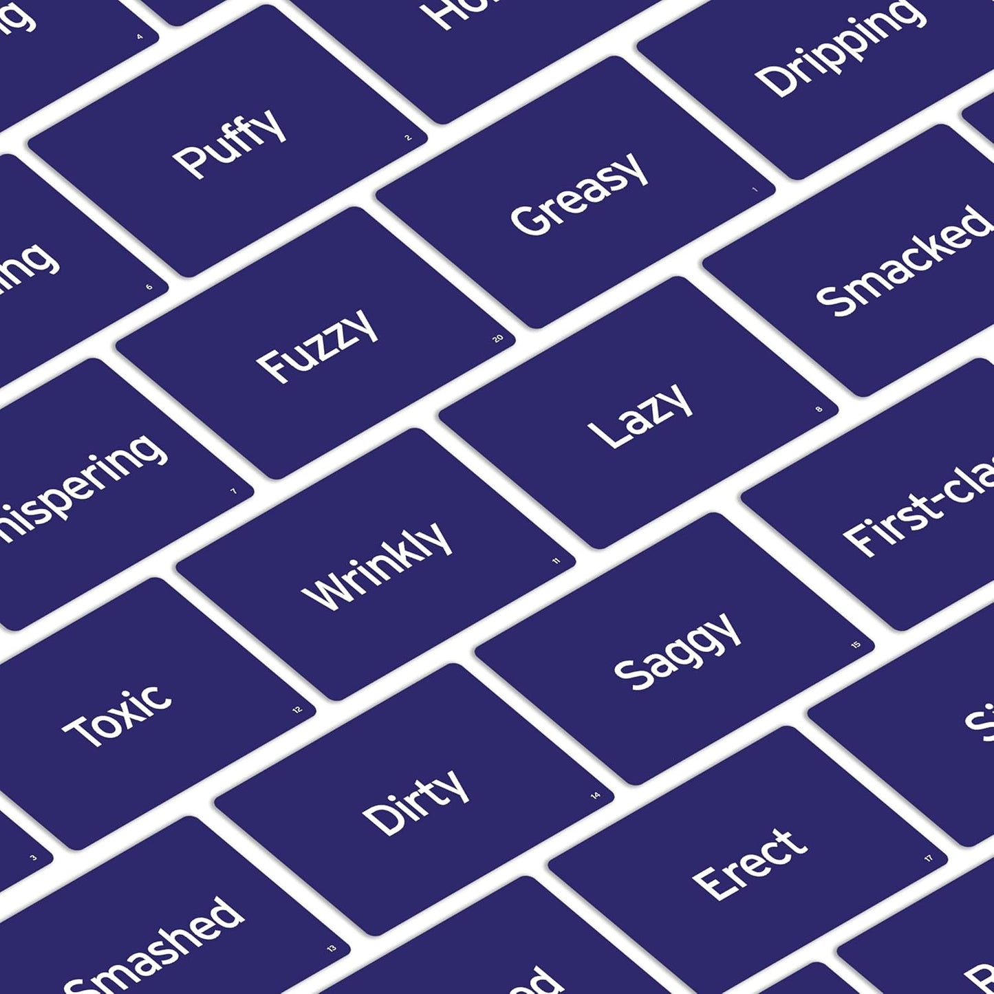 Scattered dark blue game cards showing words like "Puffy," "Greasy," "Lazy," "Wrinkly," and "Saggy"