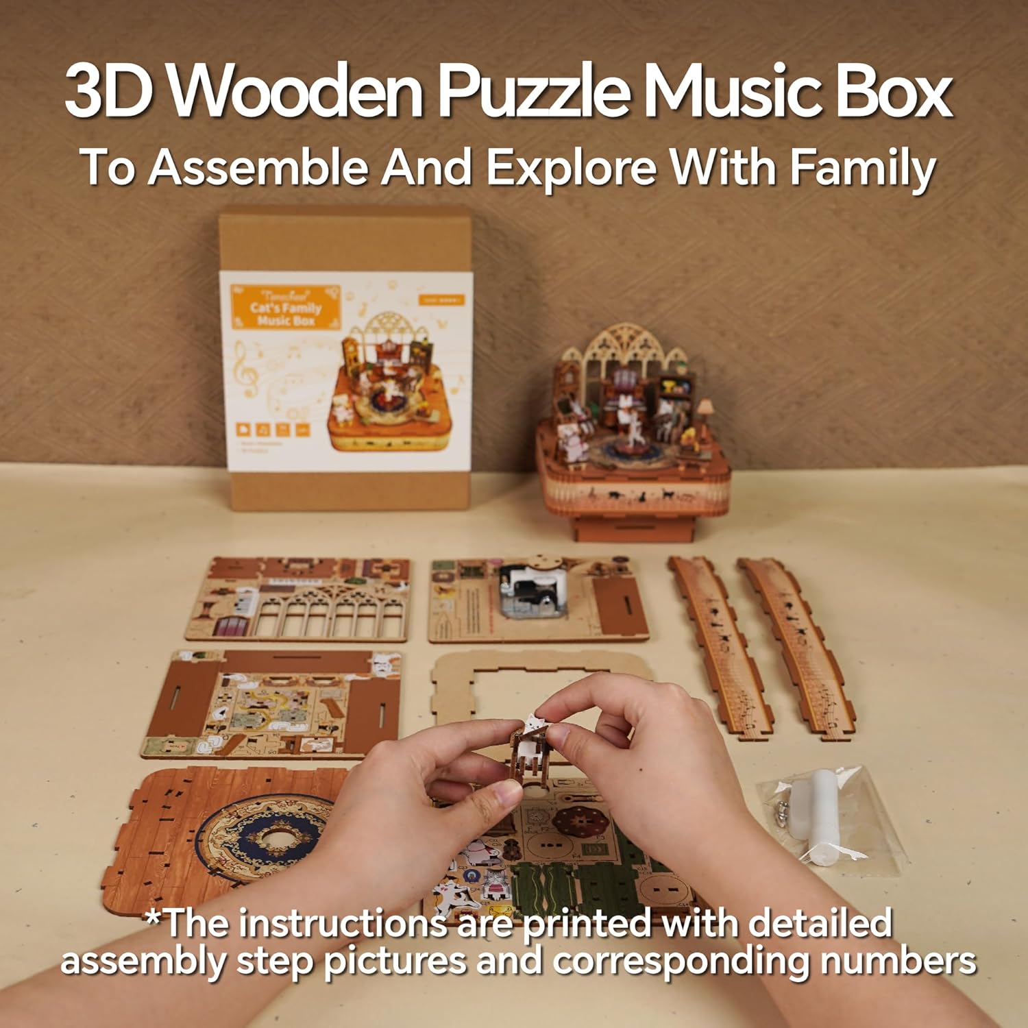 Hands assembling a piece of a 3D wooden music box puzzle. Unassembled sheets, the box, and the completed model are visible