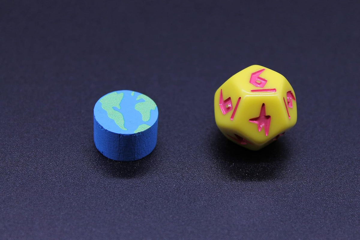 A small blue Earth token with green land, beside a yellow multi-sided die with pink numbers, on a dark surface