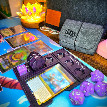 Tabletop gaming setup featuring MTG cards, purple dice, and a "Commander Damage" tracker
