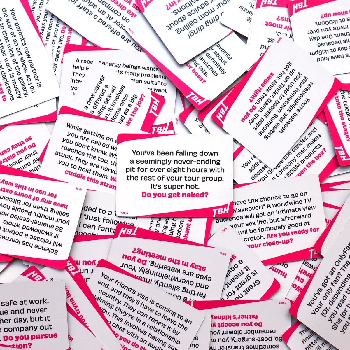 Scatter of white and pink "TBH" party game cards containing provocative text prompts and questions