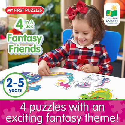 Happy child playing with four colorful fantasy puzzles (dragon, unicorn, mermaid)