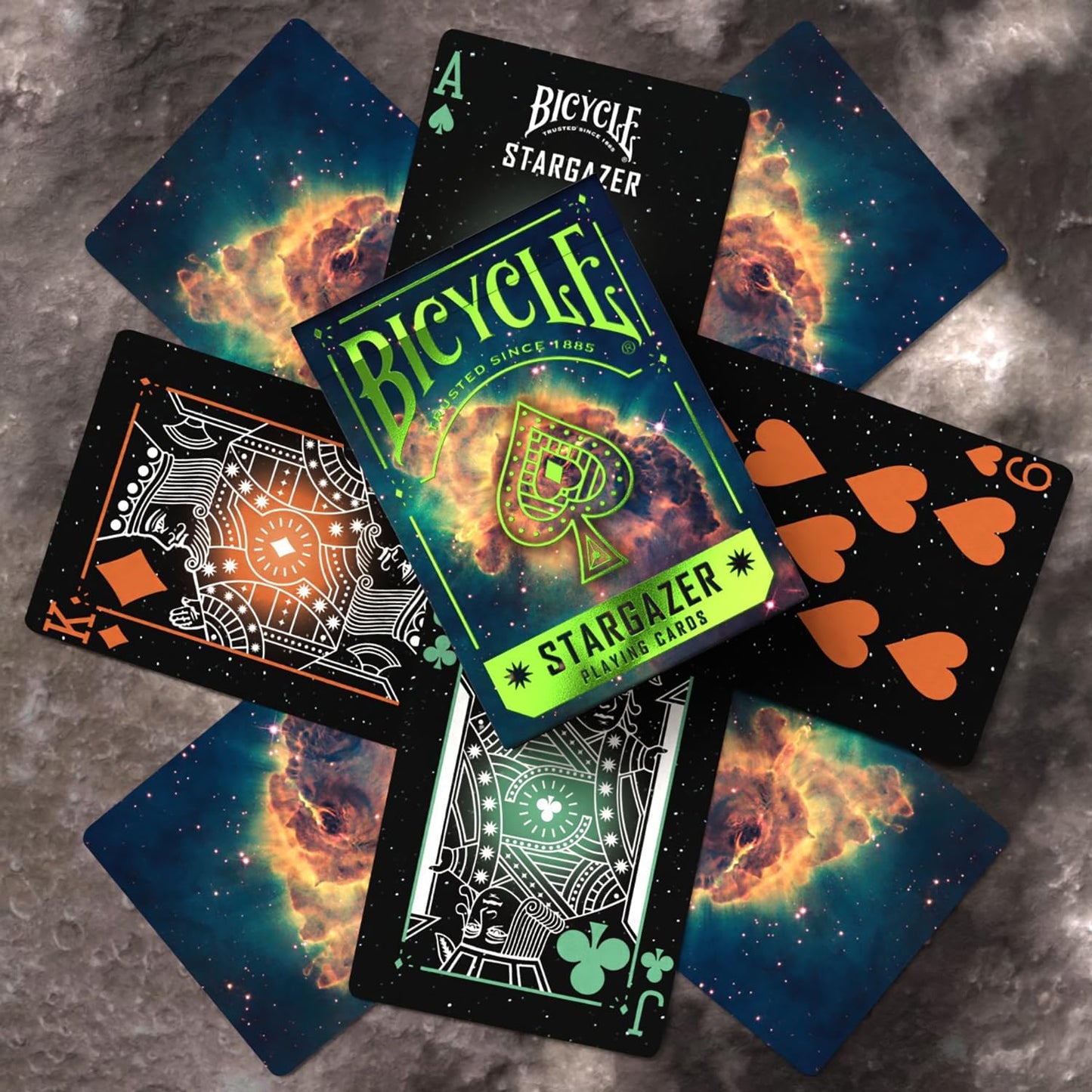 Scattered Bicycle Stargazer deck cards; space-themed backs (nebula) and custom dark face cards are visible