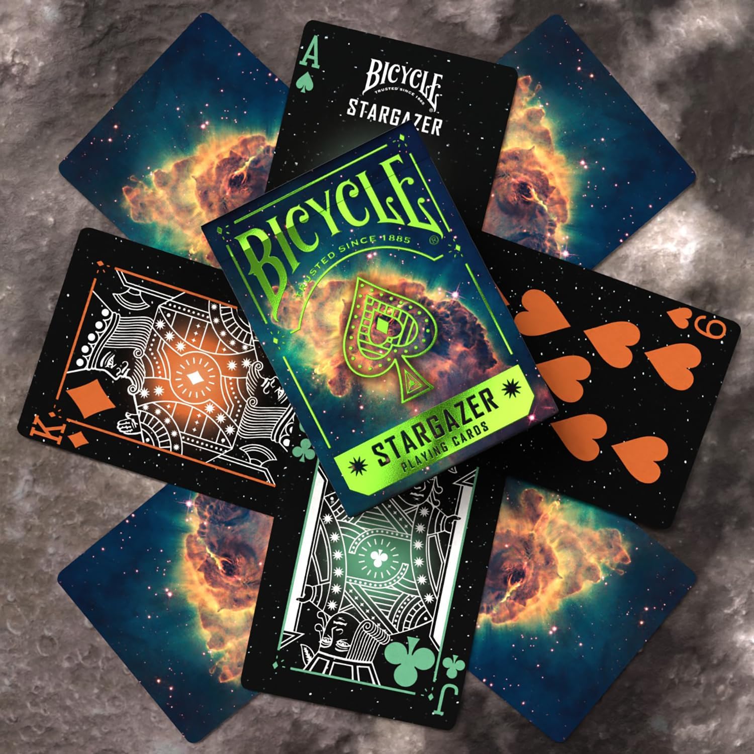 Scattered Bicycle Stargazer deck cards; space-themed backs (nebula) and custom dark face cards are visible