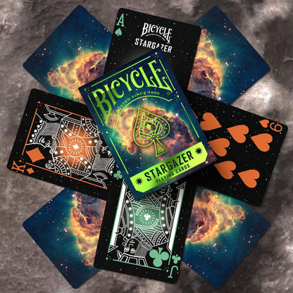 Scattered Bicycle Stargazer deck cards; space-themed backs (nebula) and custom dark face cards are visible
