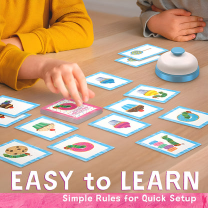 Children playing a matching card game featuring food illustrations and a bell on a wood table
