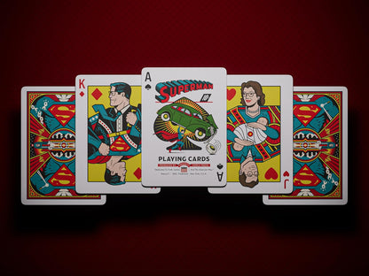 Five custom Superman playing cards. Center card, the Ace of Spades, shows Superman lifting a green car
