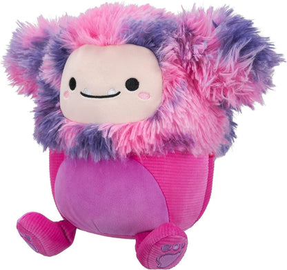 Shaggy pink and purple monster plush with a round body and a smiling face showing small fangs