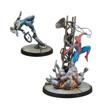 Painted miniatures showing Spider-Man swinging from a damaged radio tower engulfed in fire and Black Cat perched on a broken beam