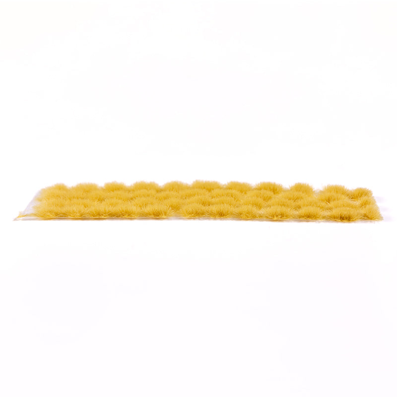 A long strip of dense autumn tufts, appearing as small yellow-brown grass clumps, against a white background