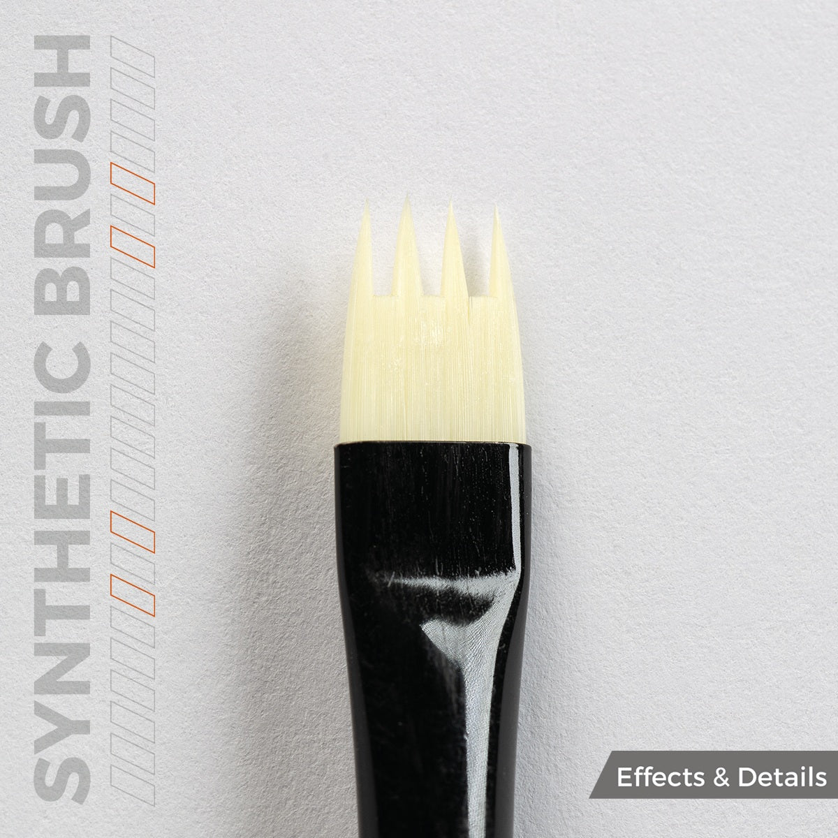Close up of a synthetic weathering brush with a black handle and four pointed light-colored bristles