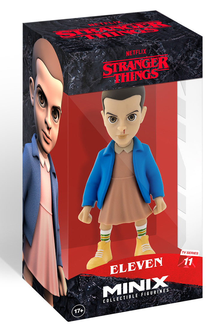 Minix Stranger Things Eleven collectible figurine with bloodied nose in a blue jacket and pink dress displayed in a clear window box