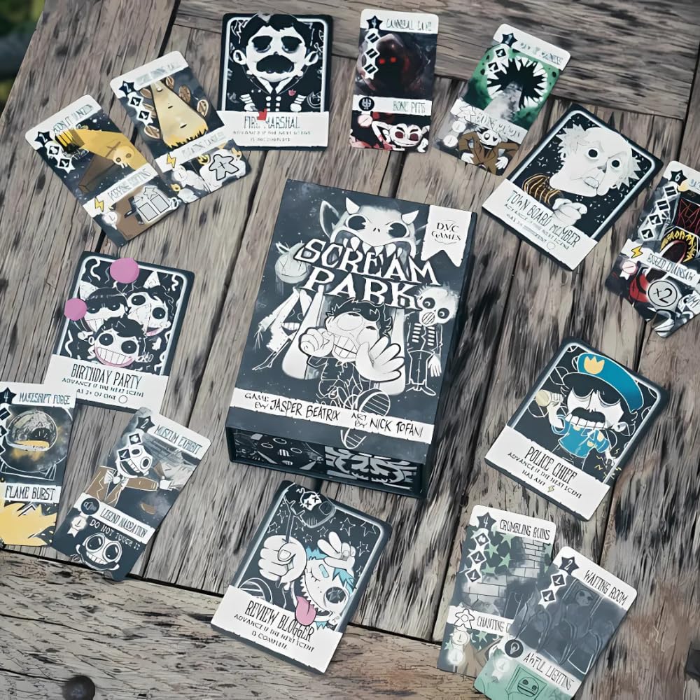 A detailed overhead shot of the Scream Park board game box and numerous brightly illustrated black and white character and action cards scattered on a rough wood surface