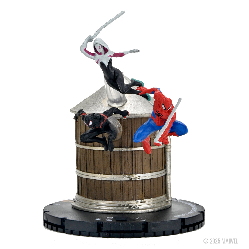 Three Spider-Verse HeroClix figures: Spider-Gwen, Miles Morales, and Spider-Man on a brown water tower base