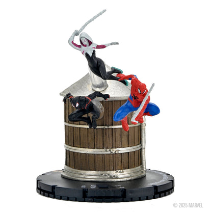Three Spider-Verse HeroClix figures: Spider-Gwen, Miles Morales, and Spider-Man on a brown water tower base