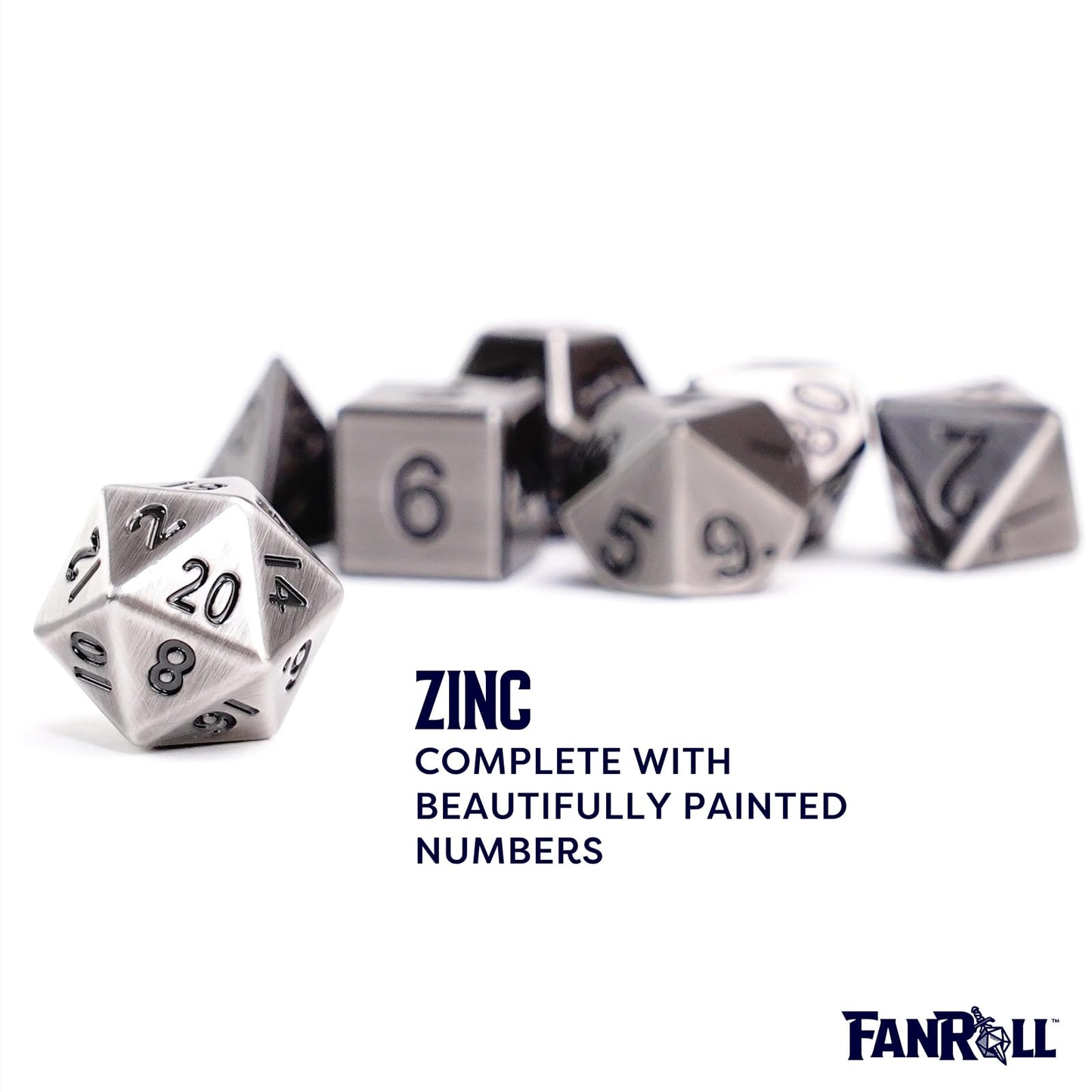 A single brushed antique silver D20 dice with black numbers is sharp in the foreground, with the rest of the polyhedral metal dice set scattered and blurred behind it