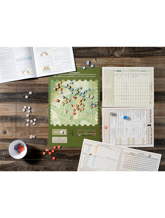 A historical wargame, "Into the Woods," set up on a wooden table with its map board, many colorful counters and rulebooks