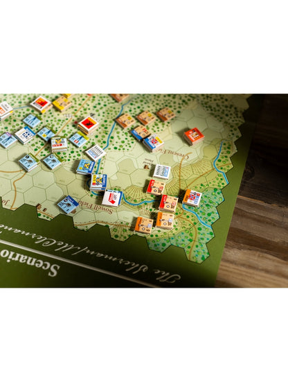 Green and tan hexagonal wargame map with numerous colorful square unit tokens placed on its terrain
