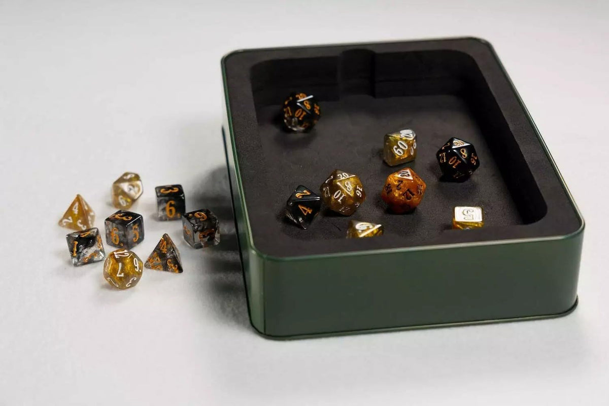 An Epic Dice Set and Rolling Tray features various clear, black, and gold polyhedral dice on a white surface and inside a dark green tray