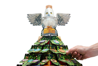Hand opens a door on a tiered Christmas tree advent calendar topped with a snowy owl holding a gift