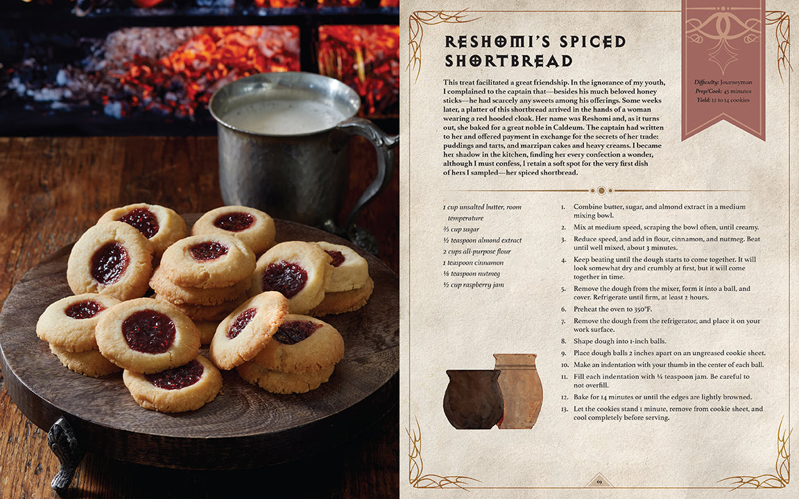 An open page from the Diablo cookbook displays the Reshomi's Spiced Shortbread recipe, with a photo of jam-filled cookies and a mug by a fire on the left, and recipe text on the right