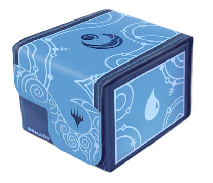 A dark and light blue Domaru trading card deck box displays intricate tribal patterns, a central swirl symbol, and the Magic: The Gathering Island mana icon