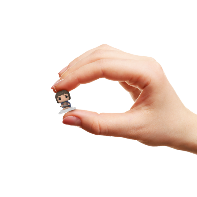 Hand holding a tiny, stylized collectible miniature figure between the thumb and index finger