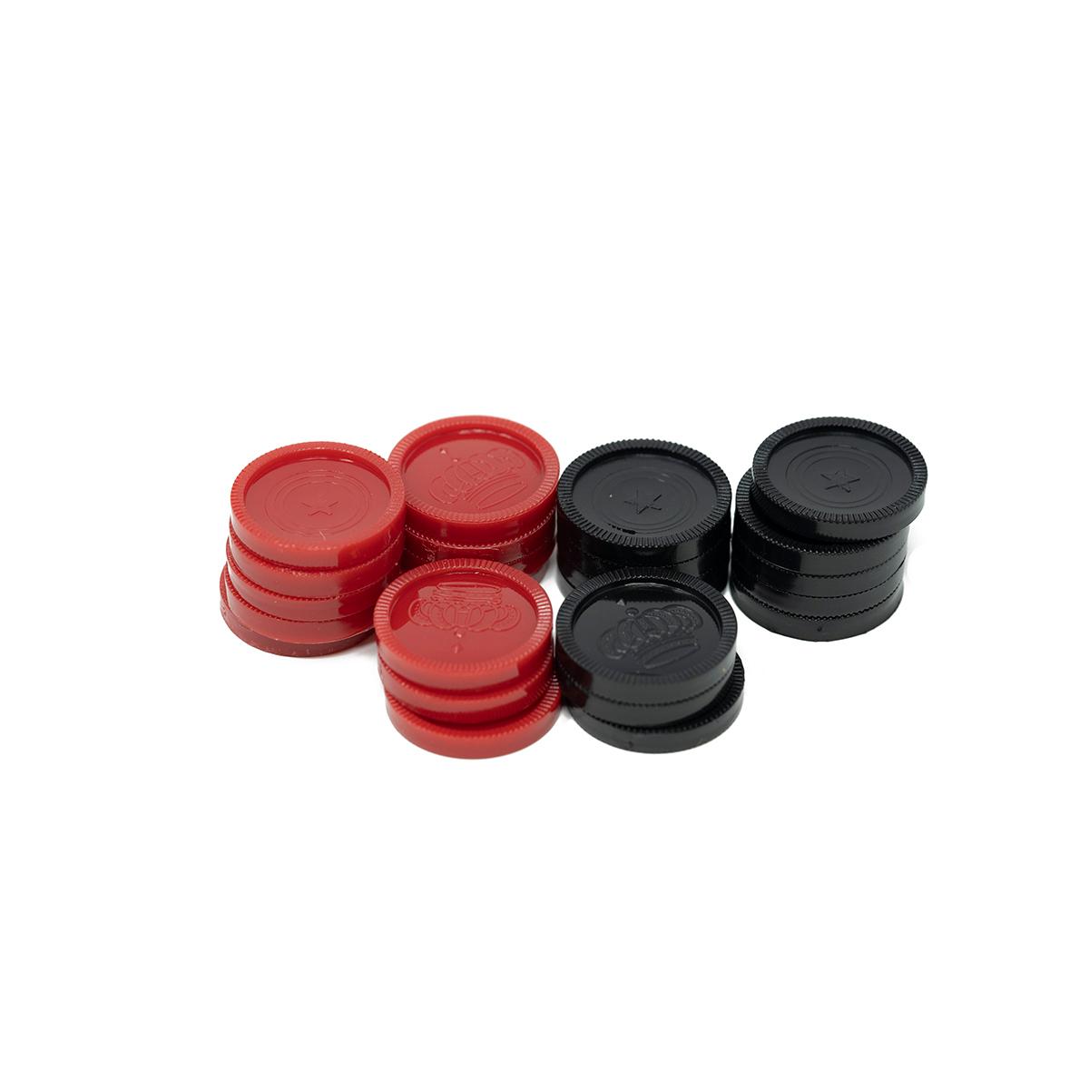 Red and black plastic checkers pieces from the Family Traditions game are stacked, clearly showing crown and star designs against a white background